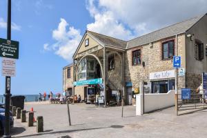 a building on the beach next to the ocean at Cedar in Bridport