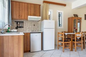 Il comprend une cuisine équipée d'un réfrigérateur blanc et d'une table. dans l'établissement Daratos apartment 3, à Céphalonie