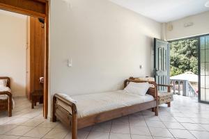 sypialnia z łóżkiem w pokoju z oknem w obiekcie Daratos apartment 3 w mieście Kefalonia