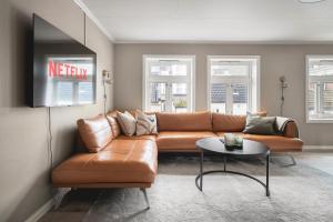 a living room with a brown leather couch and a table at Enter Viking Apartment Hotel in Tromsø