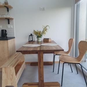 uma mesa de madeira numa cozinha com 2 cadeiras em Bujanie w sitowiu em Wyszowate