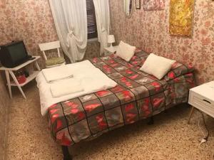 a small bedroom with a bed and a television at La Benny delle Meraviglie in Salò