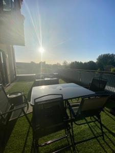 a table and chairs on a balcony with the sun shining at Charmingly cozy 2 beds apartment in Belvedere