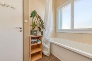 uma casa de banho com uma banheira e uma janela em Proche Parc Paul Mistral, 2 chambres, wifi, balcon em Grenoble