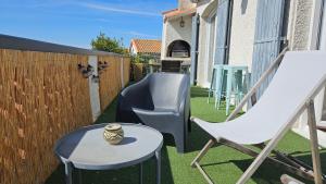 eine Terrasse mit einem Stuhl, einem Tisch und einer Schaukel in der Unterkunft Villa Farniente in Sète