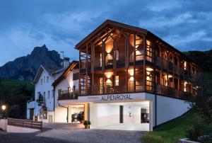 ein großes weißes Gebäude mit Balkon darüber in der Unterkunft Hotel Alpenroyal in Kastelruth