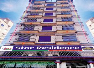 a tall building with a star resilience sign on it at Star Residence in Dhaka