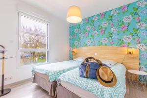 um quarto com uma cama com uma bolsa em Villa Enora Bretagne Piscine Intérieure Partagée Jacuzzi privatif 100m Plage em Sibiril
