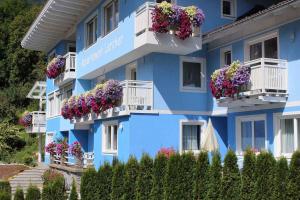 um edifício azul com flores nas varandas em Flattach Apartment 1 em Ausserfragant