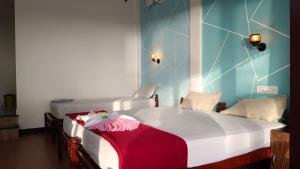 a bedroom with a large white bed with a red blanket at Cherai Ocean View Home in Cherai Beach +51 photos