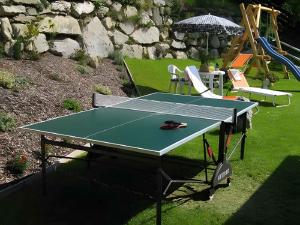 una mesa de ping pong en un patio con sombrilla en Flattach Apartment 2, en Ausserfragant