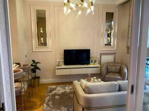sala de estar con sofá y TV en Emaar’da konforlu bir konaklama, en Estambul