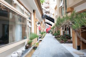 um beco vazio entre dois edifícios com vasos de plantas em Memory Garden House em Xian
