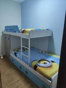 Ce lit se trouve dans un dortoir doté de 2 lits superposés et d'un mur bleu. dans l'établissement EL NIDO, à Montoro