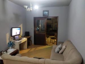 uma sala de estar com um sofá e uma televisão em Hospedagem ao lado da Oktober para 5 pessoas em Blumenau