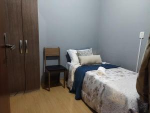 um pequeno quarto com uma cama e uma cadeira em Hospedagem ao lado da Oktober para 5 pessoas em Blumenau