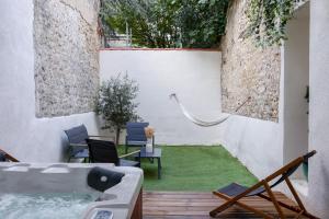 a backyard with a hot tub and a green lawn at La Romance à Bulles en Hyper Centre in La Rochelle