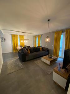 a living room with yellow curtains and a couch at Apartments by KEN in Ramstein-Miesenbach