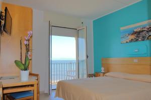 - une chambre avec un lit et une vue sur l'océan dans l'établissement Albergo La Sirenella, à Sperlonga