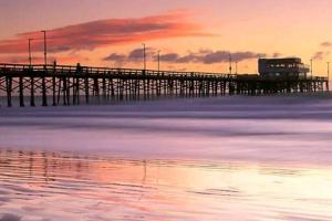 a pier on the water with a sunset at Newport Beach Living (1 blk to beach and 25 min to Disney) in Newport Beach