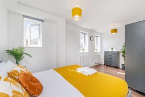 a bedroom with a bed with a yellow blanket at Luxury 2 Bed 2 Bath London Home - Vauxhall, Battersea & Nine Elms in London