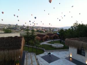 un grupo de globos de aire caliente volando en el cielo en A la mode Cappadocia, en Göreme