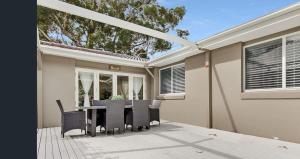 a house with a table and chairs on a deck at Boho Beach House in Vincentia