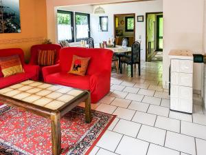 Herdwangen-SchönachにあるIm Herzen der Naturの赤いソファとテーブルのあるリビングルーム