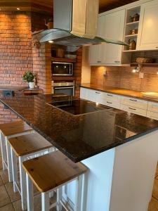 a kitchen with a large counter with wooden stools at Tirmo Strand in Porvoo
