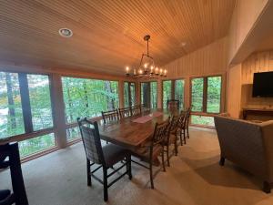 Un comedor con una gran mesa y sillas de madera. en Serenity On Lake Owen Condo, en Cable