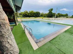 une grande piscine installée à côté d'une maison dans l'établissement Lakefront Tree Escape in Buriram, Thailand, à Buriram