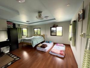a bedroom with two beds and a wooden floor at Lakefront Tree Escape in Buriram, Thailand in Buriram +18 photos