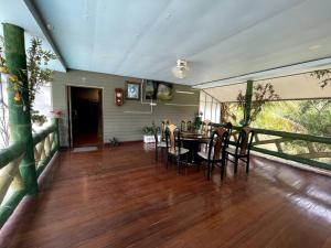 a dining room with a table and chairs on a deck at Lakefront Tree Escape in Buriram, Thailand in Buriram