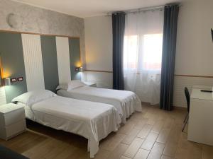 a hotel room with two beds and a window at Hotel Malpensafiera in Bernate Ticino