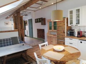 cocina y comedor con mesa de madera en Apartament Jesionek agroturystyka, en Jaszkotle