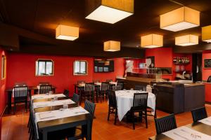un ristorante con tavoli, sedie e pareti rosse di Hotel King, by R Collection Hotels a Varedo