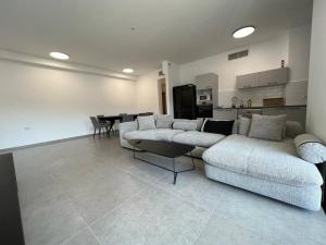 a living room with a couch and a table and a kitchen at Menahem Arber 5 Bedrooms in Tel Aviv