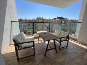 Habitación con balcón con mesa y 2 sillas. en Menahem Arber 5 Bedrooms, en Tel Aviv