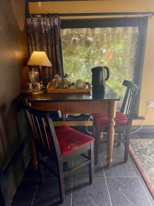 an old table with a lamp and a chair and a table with a window at The Waters Country House in Ballyvaughan