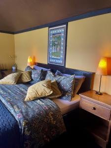 una camera da letto con un letto con cuscini sopra di The Waters Country House a Ballyvaughan