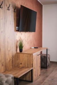 uma secretária de madeira com uma televisão na parede em Hotel Restaurant Domestika em Skopje