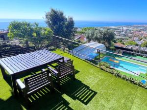 un patio con 2 panche e una piscina di Villa con piscina privada climatizada 29ºC a Santa Susanna