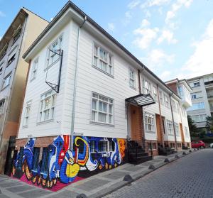 un bâtiment blanc avec une fresque murale sur son côté dans l'établissement Best Pasaport Pier Otel Kadıköy, à Istanbul