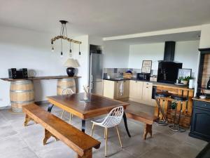 eine Küche mit einem Holztisch sowie einem Tisch und Stühlen in der Unterkunft Gîte de Lamothe in Pimbo