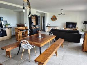 sala de estar con mesa de madera y sillas en Gîte de Lamothe, en Pimbo