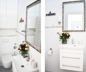 a bathroom with a white sink and a mirror at Bellevue C14 in Großenbrode