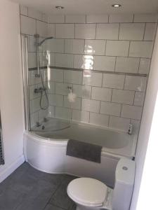 a bathroom with a toilet and a bath tub with a sink at Central Morecambe, minimalist seaside flat N.1 in Morecambe