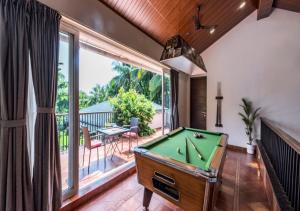 Habitación con mesa de billar y balcón. en SaffronStays Osaree, Kihim - pet-friendly pool villa perfect for a workcation, en Alibaug