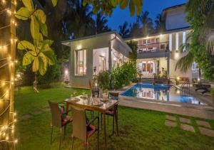 un patio trasero con una mesa y sillas y una casa en SaffronStays Osaree, Kihim - pet-friendly pool villa perfect for a workcation, en Alibaug 69 fotos más