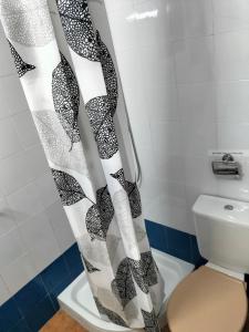 a bathroom with a shower curtain next to a toilet at FINCA RIODIEL in Gibraleón